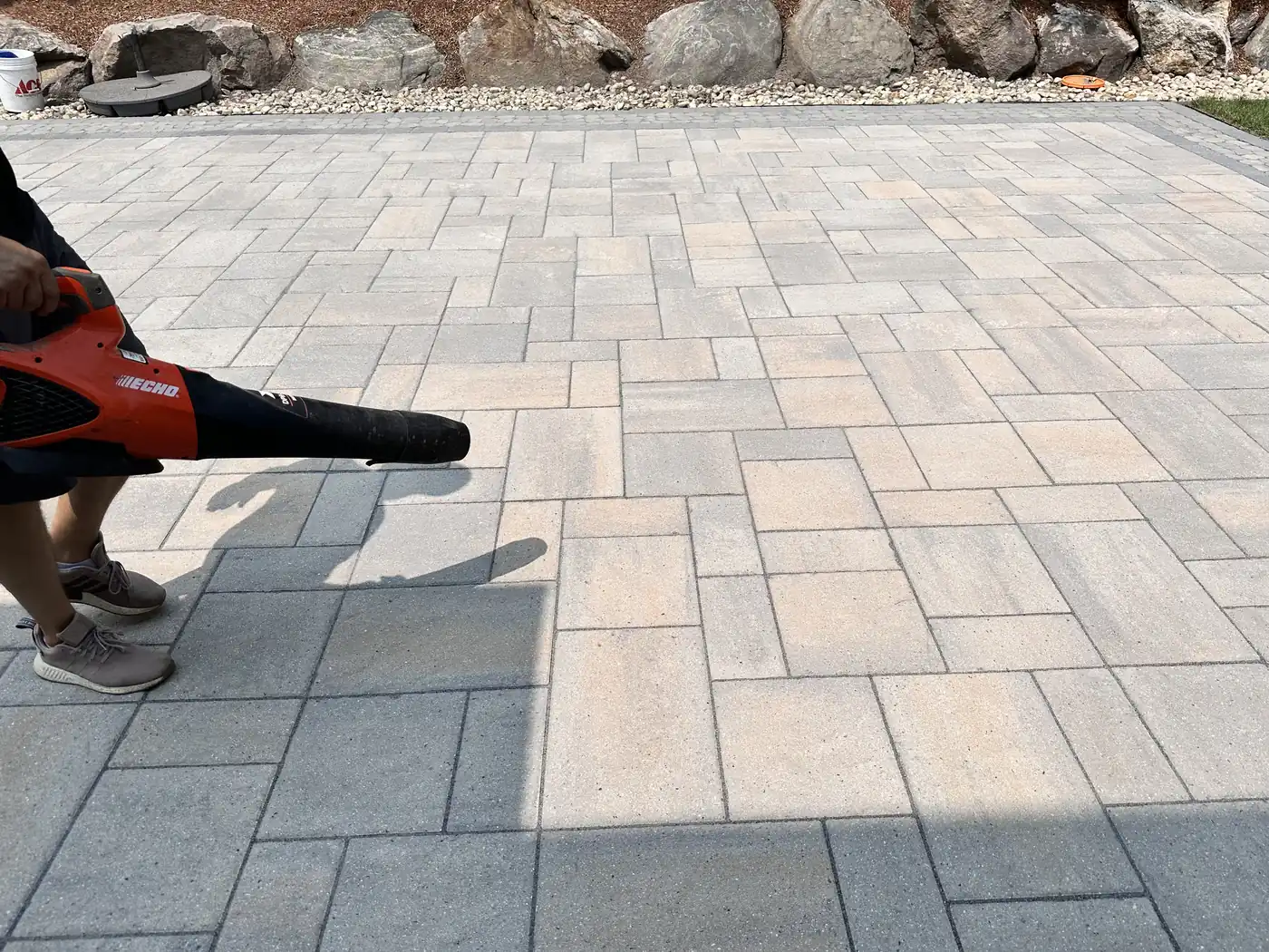 Prep before sealing, Avon Blowing debris off a paver patio with a leaf blower before sealing in Avon, CT