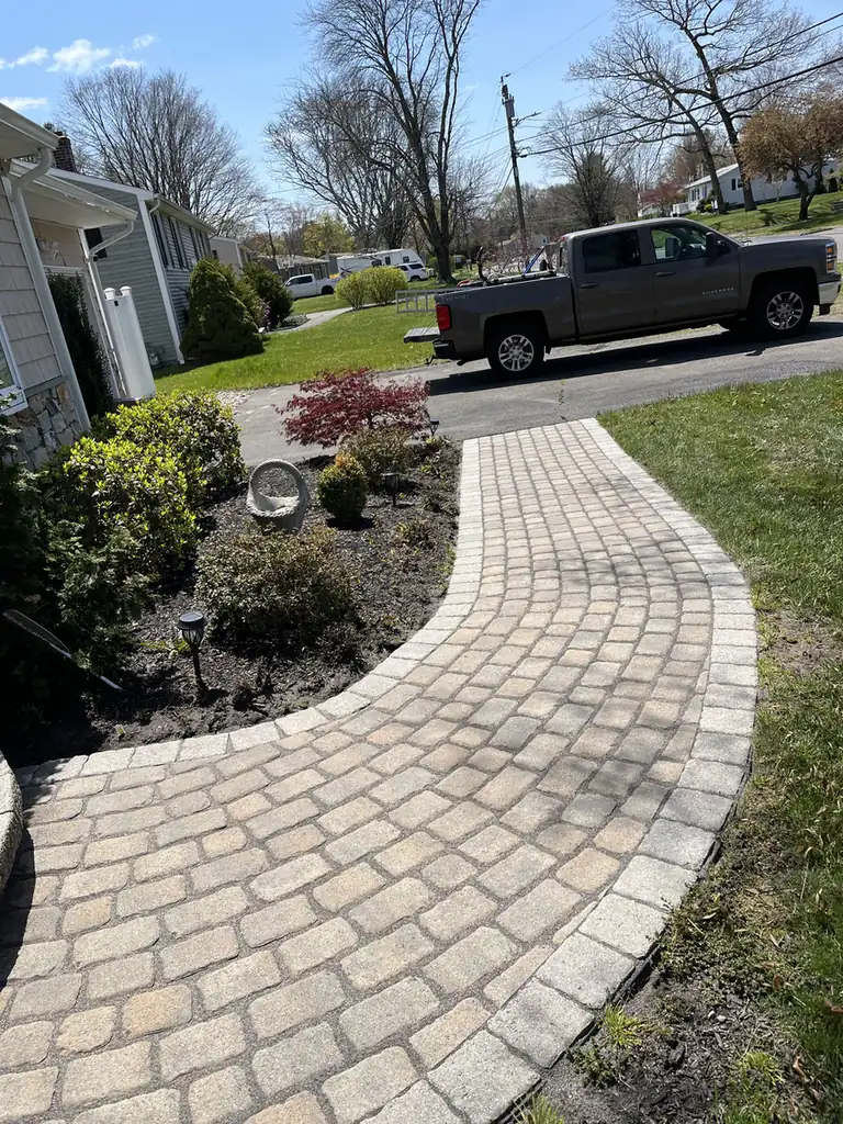 Cobble paver walkway with a soldier-course border curving through a front garden in Southington, CT