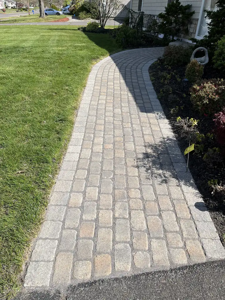 Re-sanded cobble paver walkway with a soldier border running along a front lawn in Southington, CT