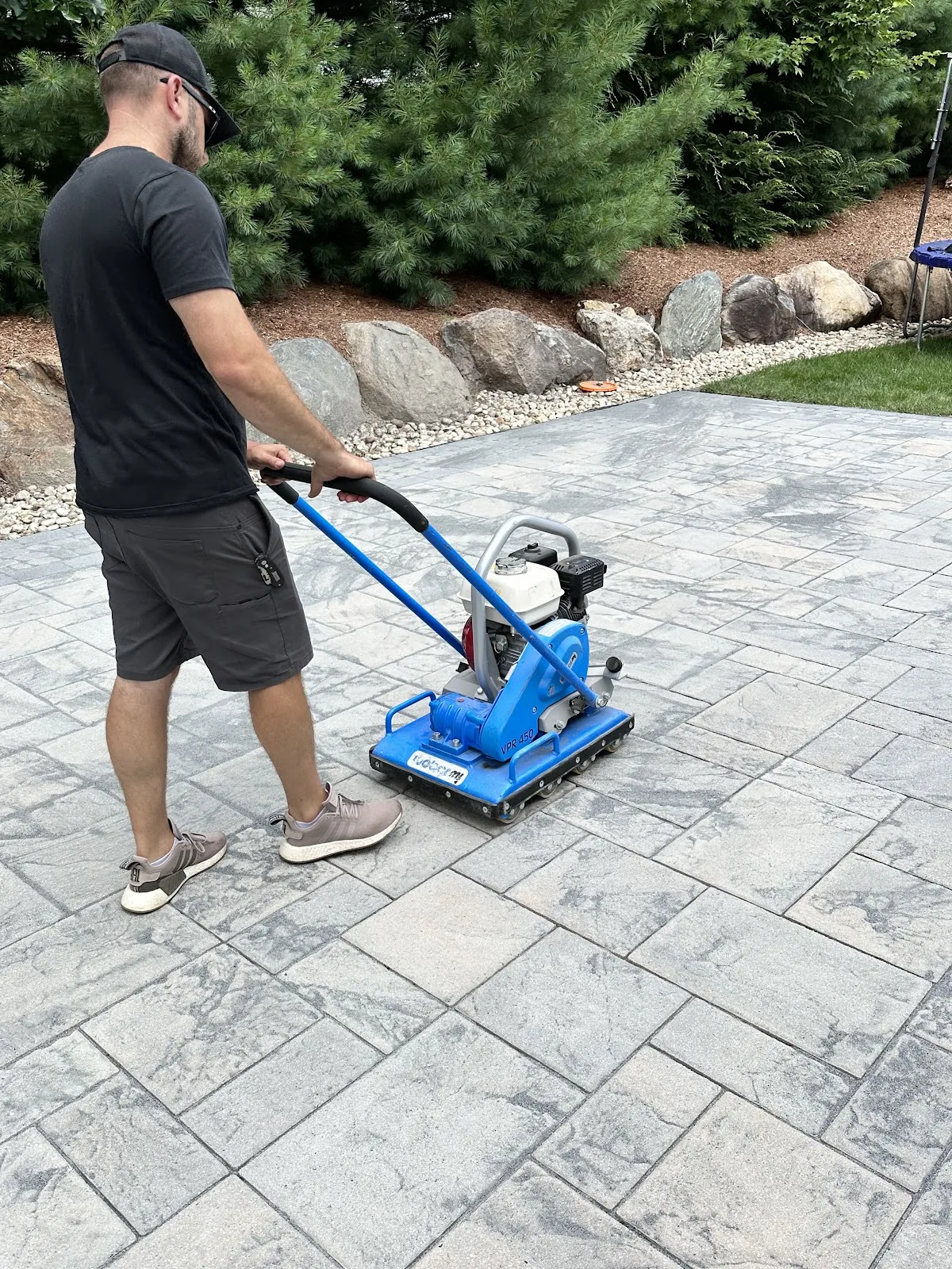 Compacting fresh joint sand between pavers before sealing in Northwest Connecticut