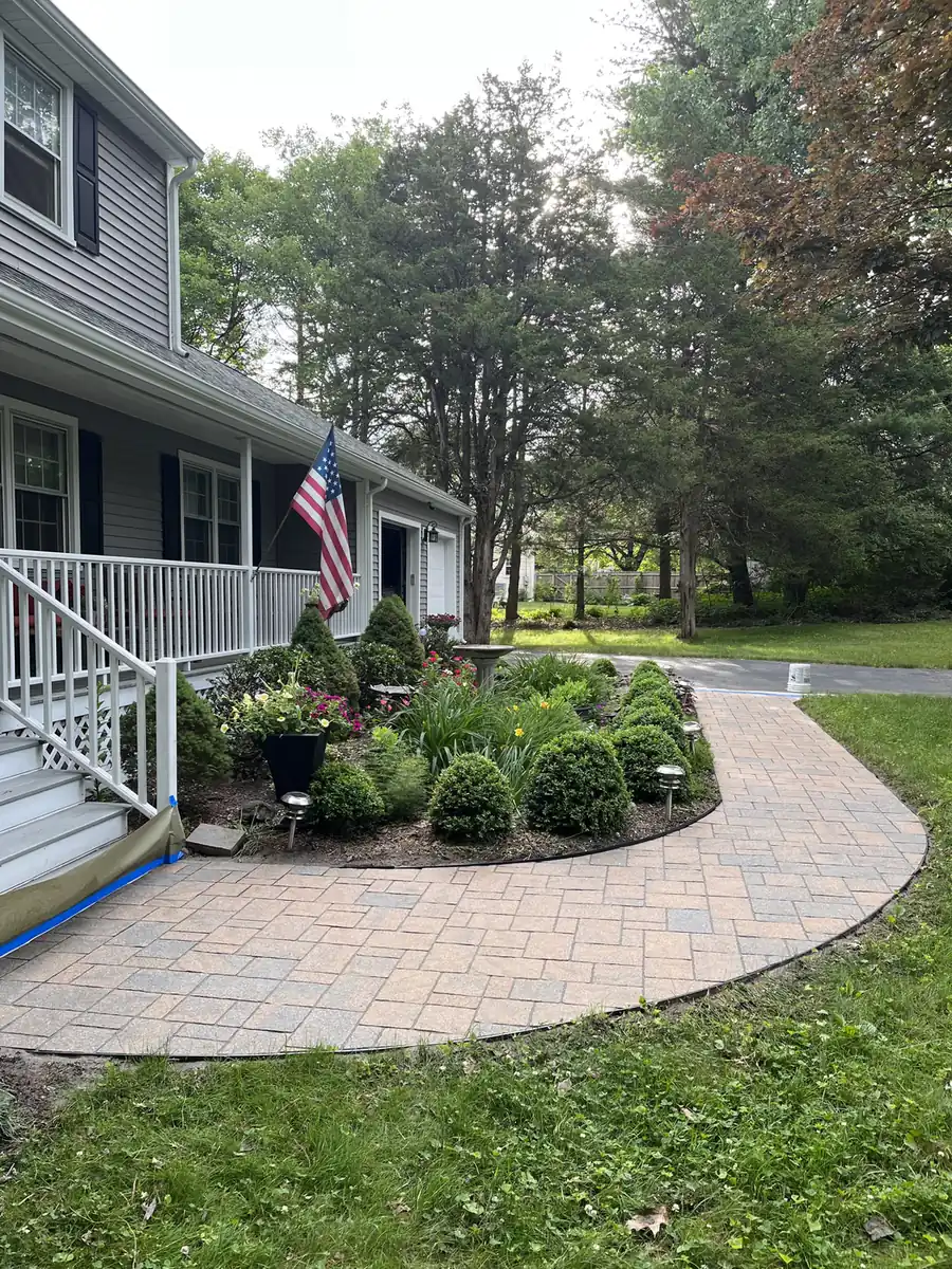 Curved front walkway, Avon Curved rose and gray paver walkway wrapping a front garden at a porch with a flag in Avon, CT
