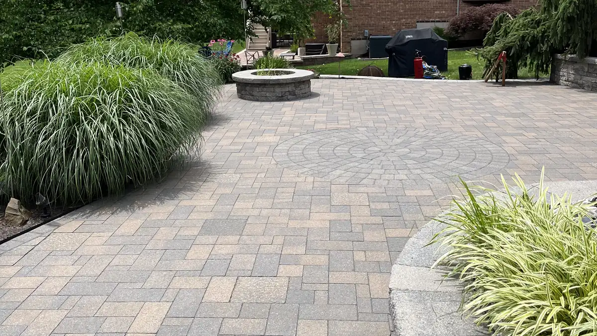 Large patio, Rocky Hill Large paver patio with a fire pit and curved planter wall behind a brick home in Rocky Hill, CT
