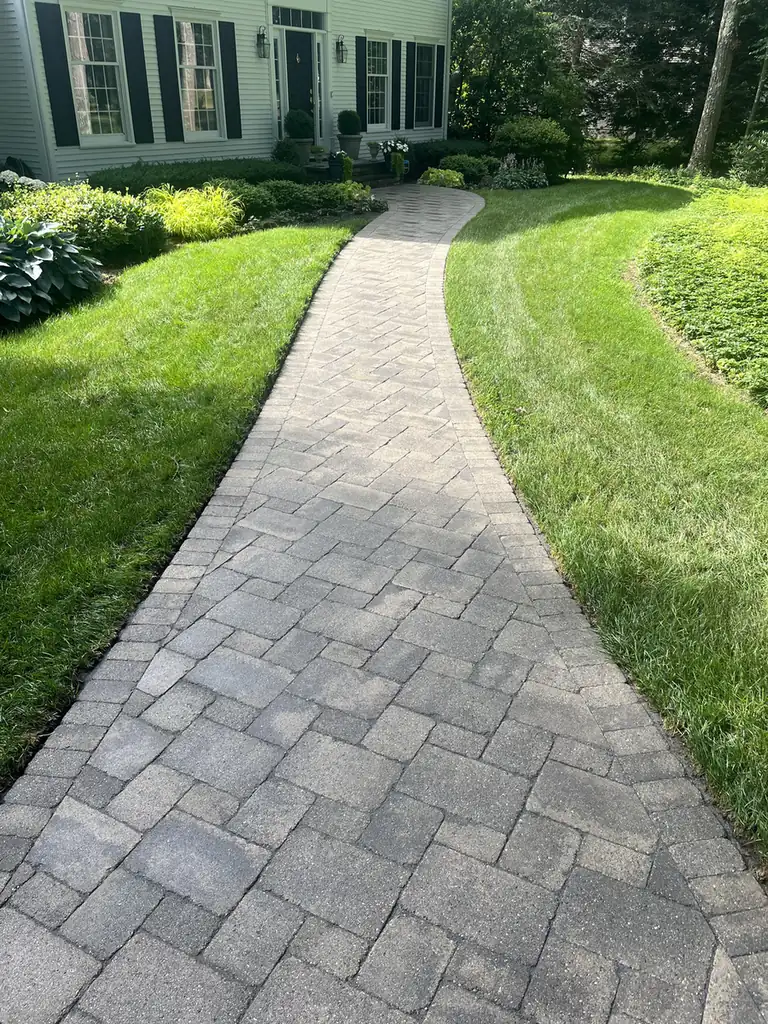 Long curving paver front walk crossing a lawn to a colonial home after cleaning in Avon, CT