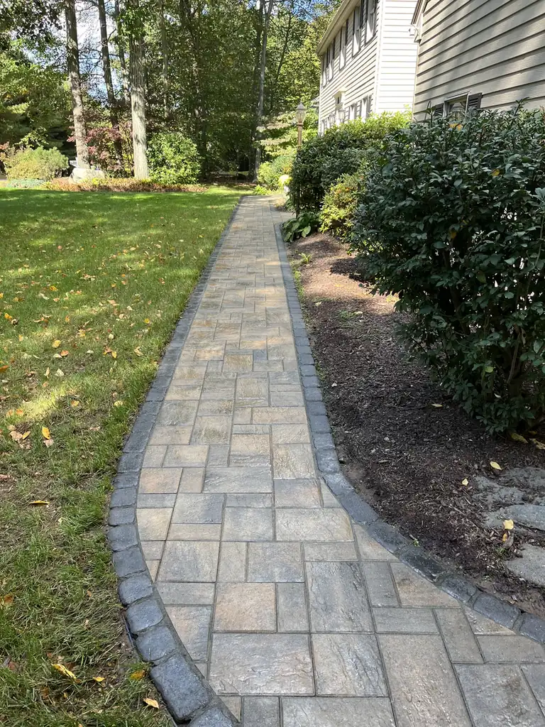 Side path, Avon Narrow paver side path with a cobble edge curving along a house and shrubs in Avon, CT