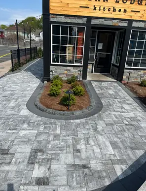 Sealed paver entry court Sealed gray paver entry court with a planted island outside a restaurant storefront in Connecticut