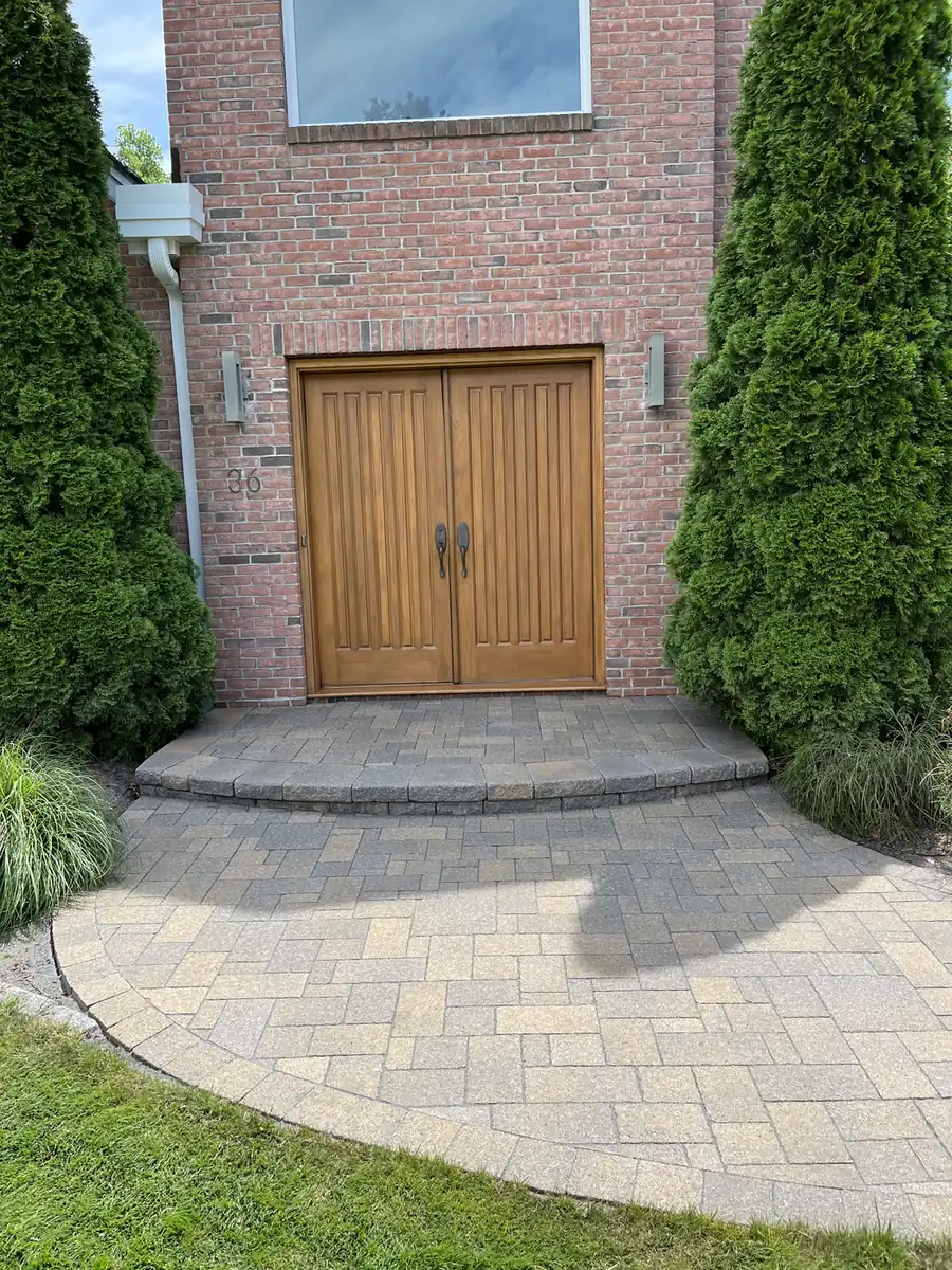 Paver entry landing with a rounded step at double wood doors, cleaned and sealed in Rocky Hill, CT
