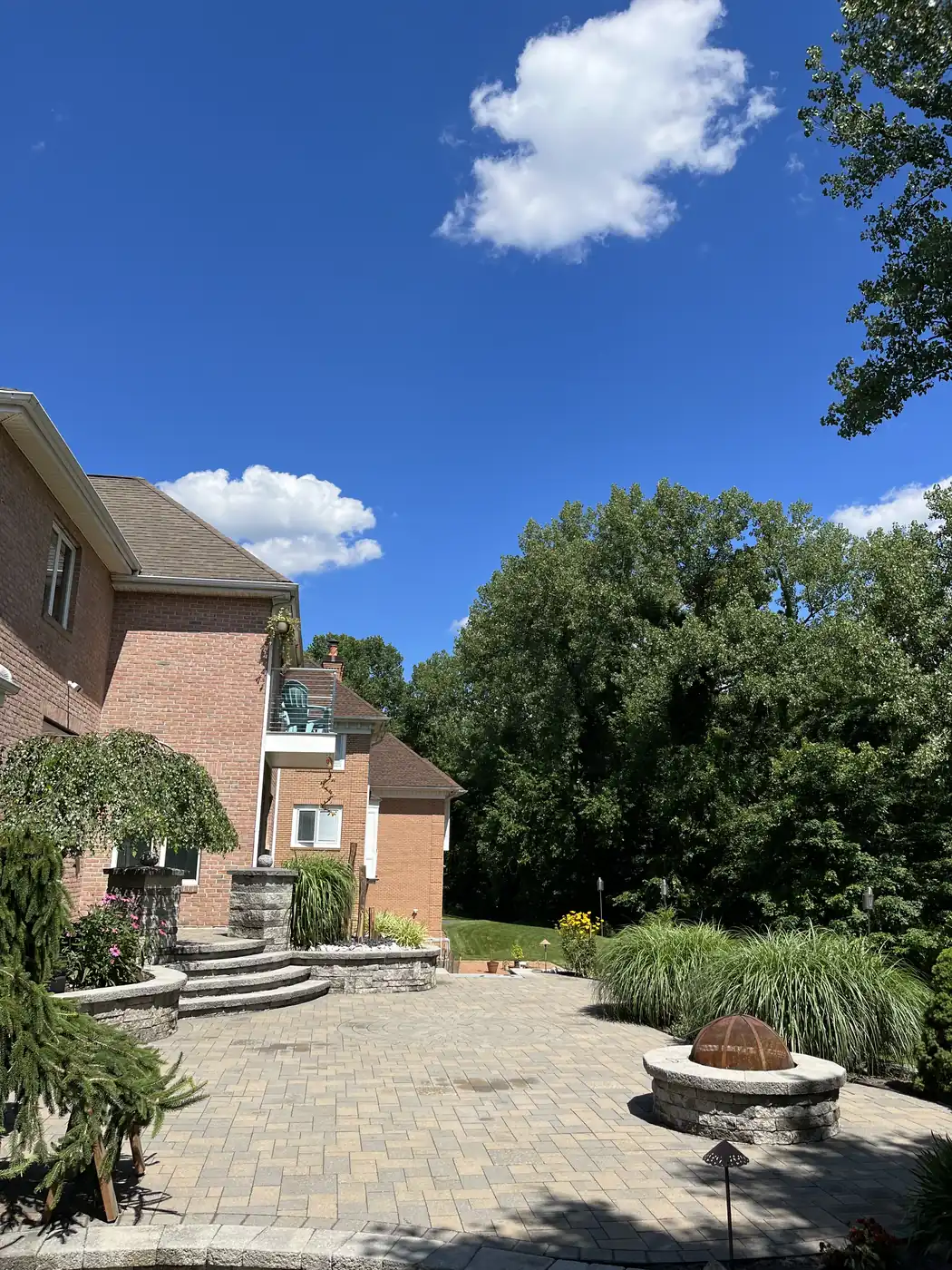 Fire pit terrace, Rocky Hill Paver patio with a stone fire pit and terraced steps behind a brick home in Rocky Hill, CT