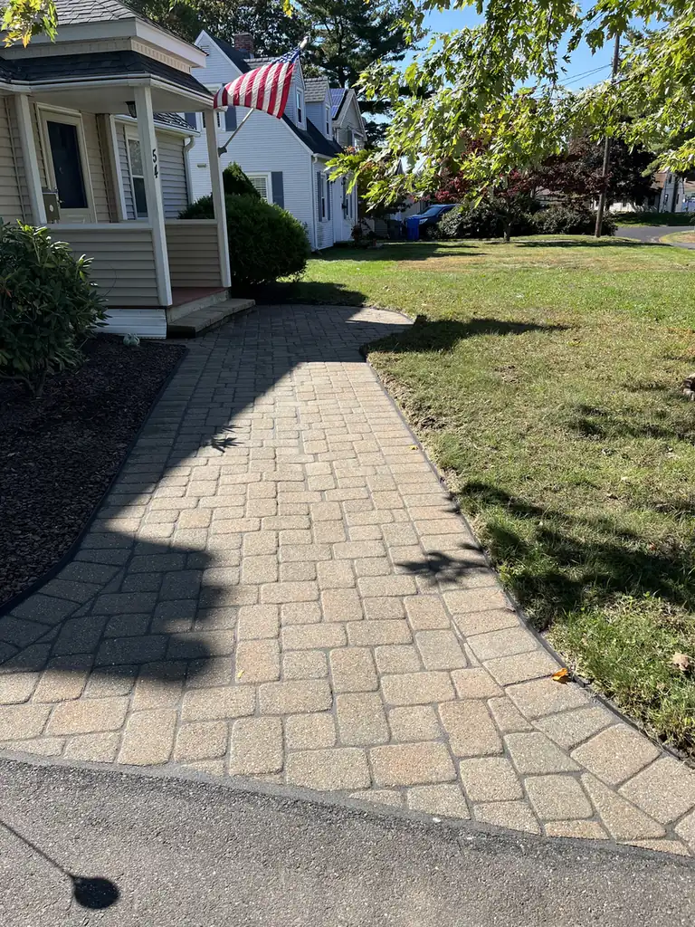 Paver walkway with a dark border leading from the driveway to a front porch in Bristol, CT