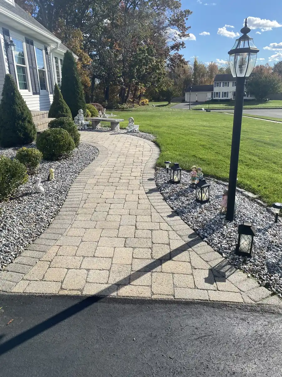 Lamppost walkway, South Windsor Tan paver walkway winding past a lamppost and decorative gravel beds in South Windsor, CT