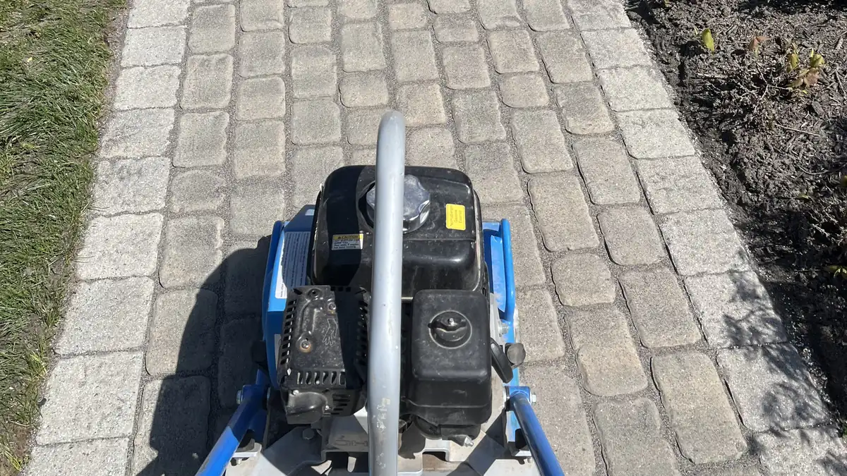 Plate compactor setting fresh joint sand on a cobble paver walkway during repair work in Southington, CT