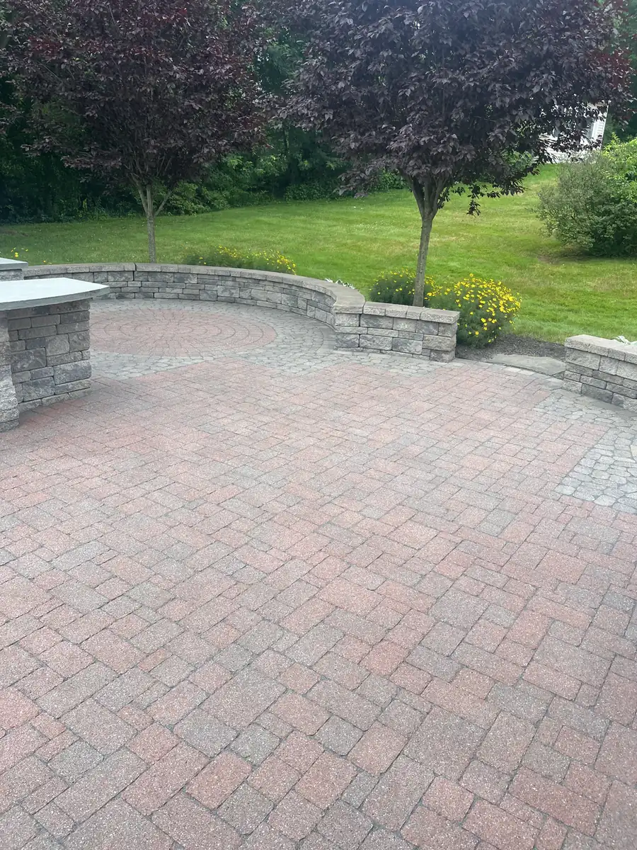 Red herringbone paver patio with a curved stone seat wall and counter in Middletown, CT