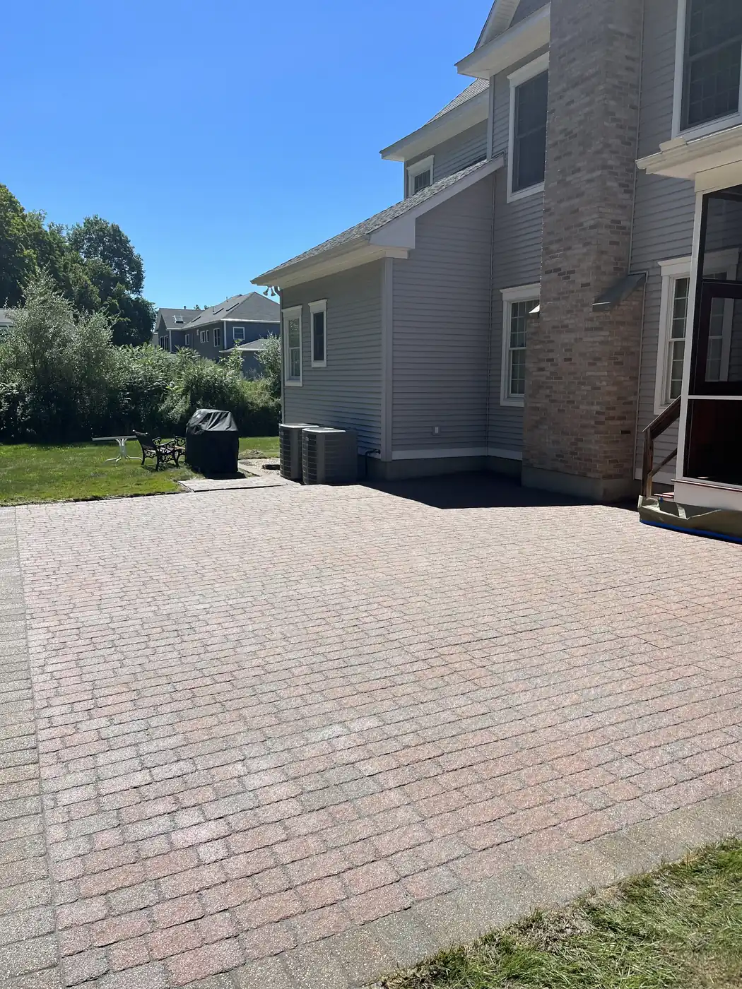 Large red tumbled-paver patio cleaned and re-sanded behind a home in Southington, CT