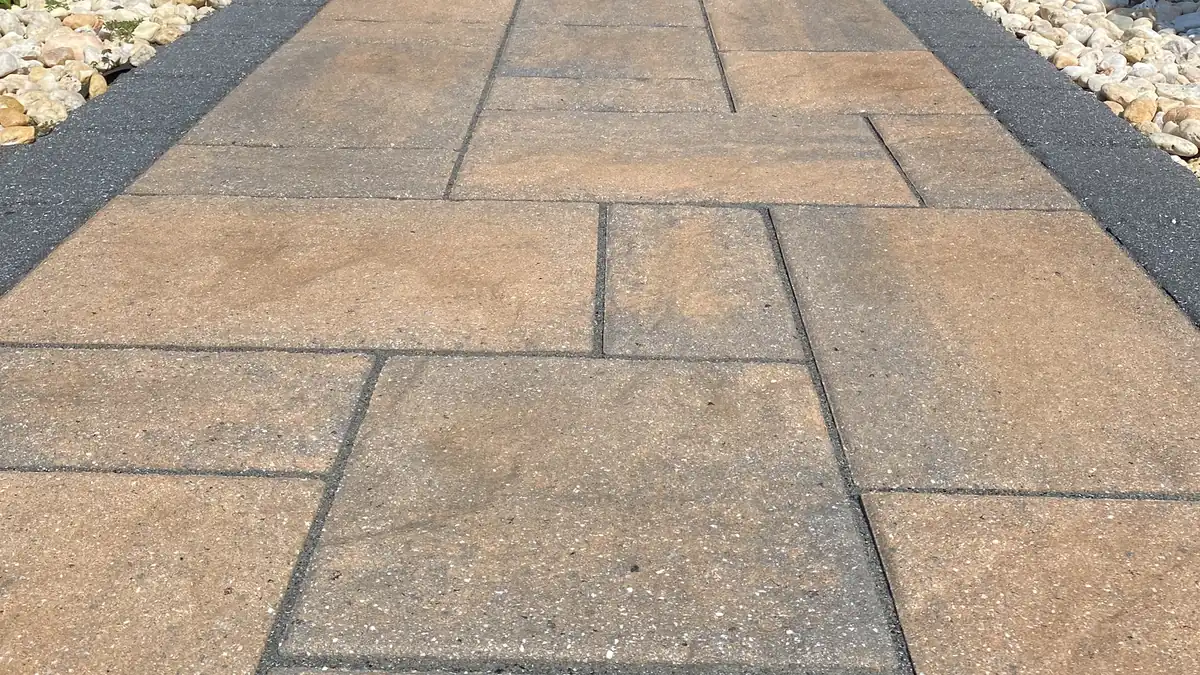Sealed slab walkway, Southington Sealed tan slab paver walkway with a charcoal border between white gravel beds in Southington, CT