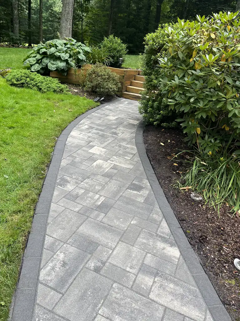 Slab walkway, Simsbury Gray slab paver walkway with a charcoal border running past rhododendrons to timber steps in Simsbury, CT